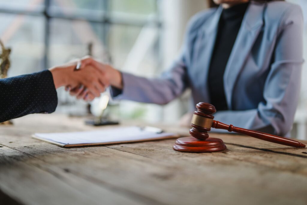 Two lawyers shaking hands after signing a legal contract
