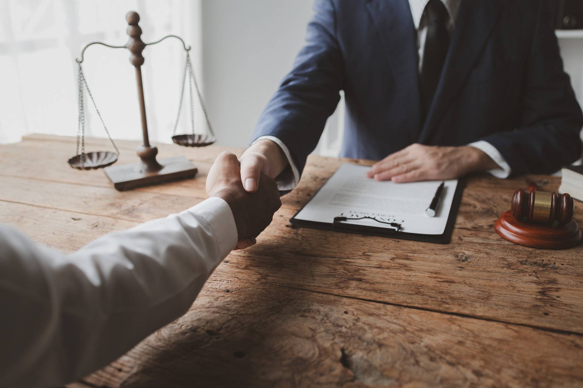 Handshake at lawyer&rsquo;s office with contract