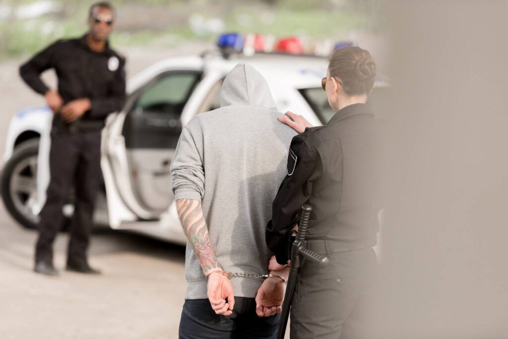 Candid shot from behind of a person being arrested